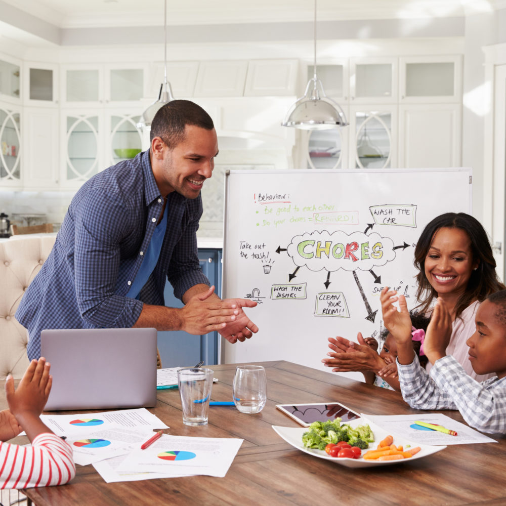 Family clapping at a domestic meeting in their kitchen