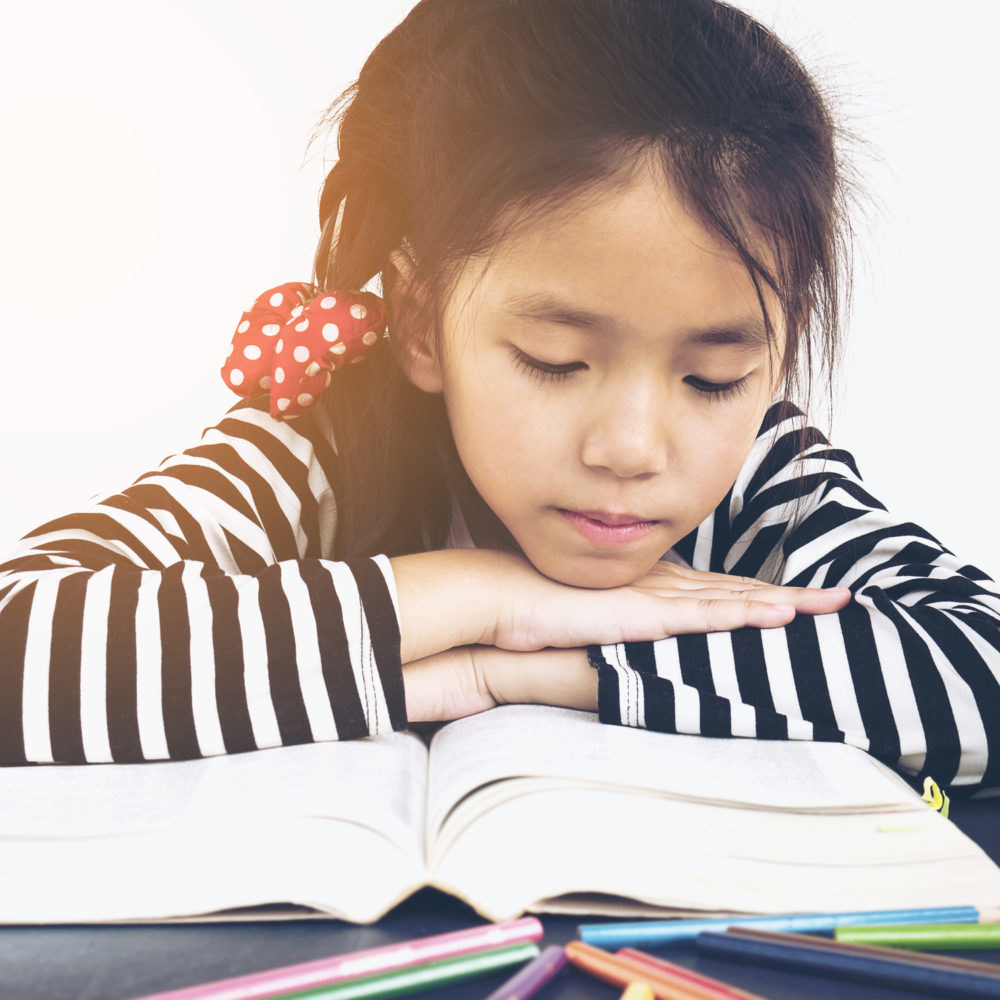 Asian kid is reading book - Crossroads Family Counseling Center