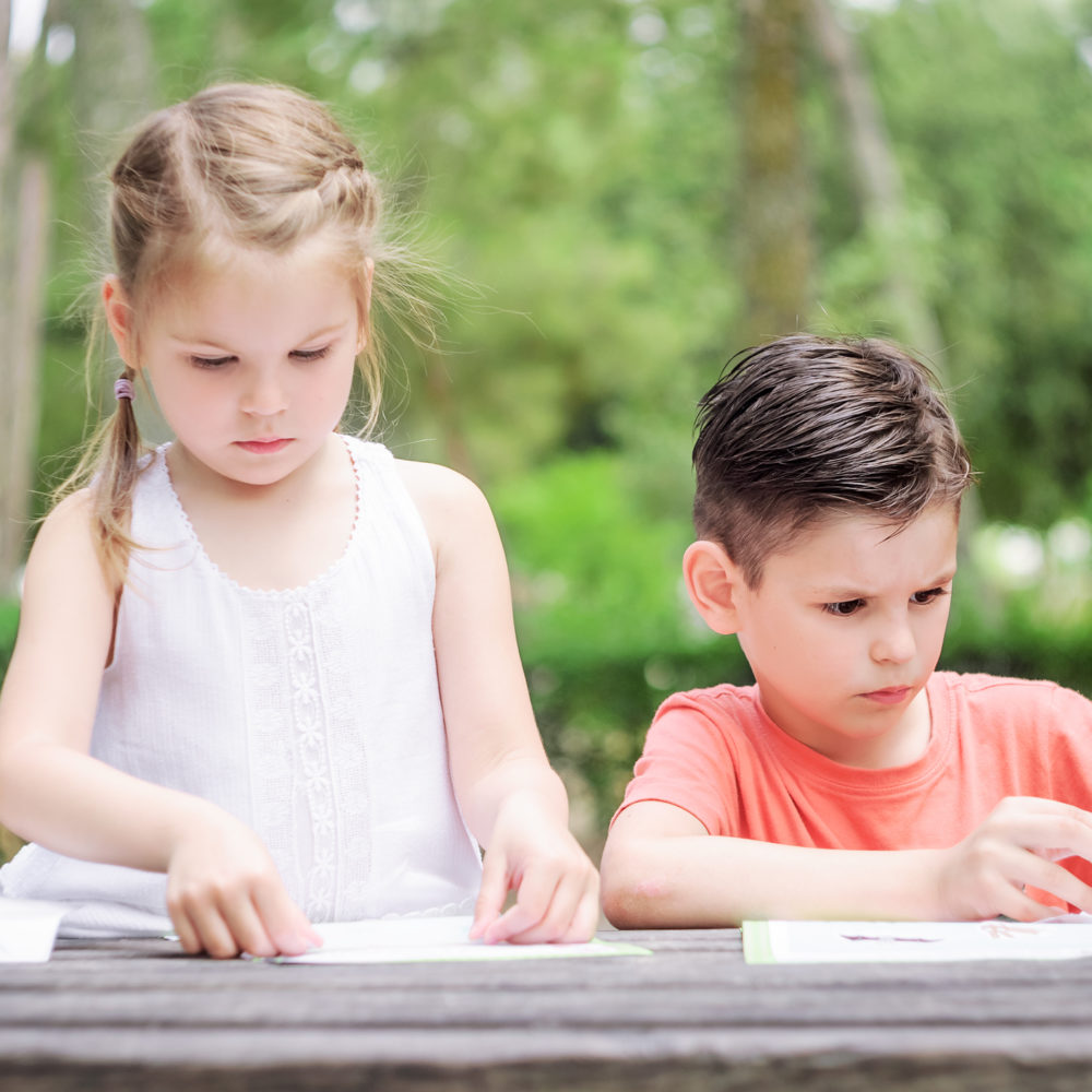 Hapy kids  learn in a park. Brother and sister together do the j